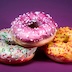 3 colorful donuts on purple background